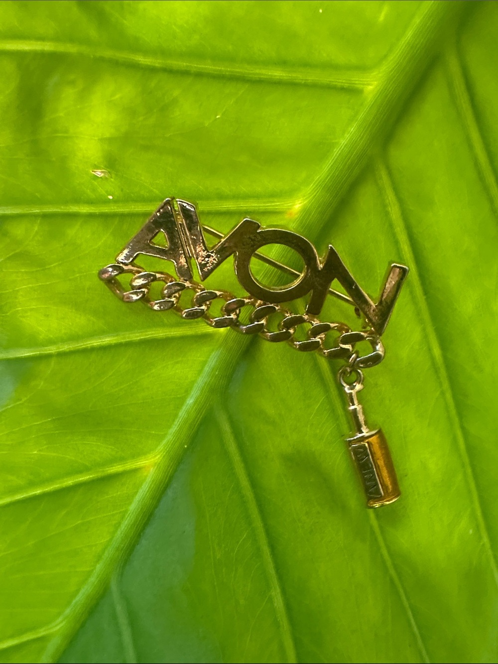 Avon Gold-tone Script Logo Pin with Chain and Perfume Charm